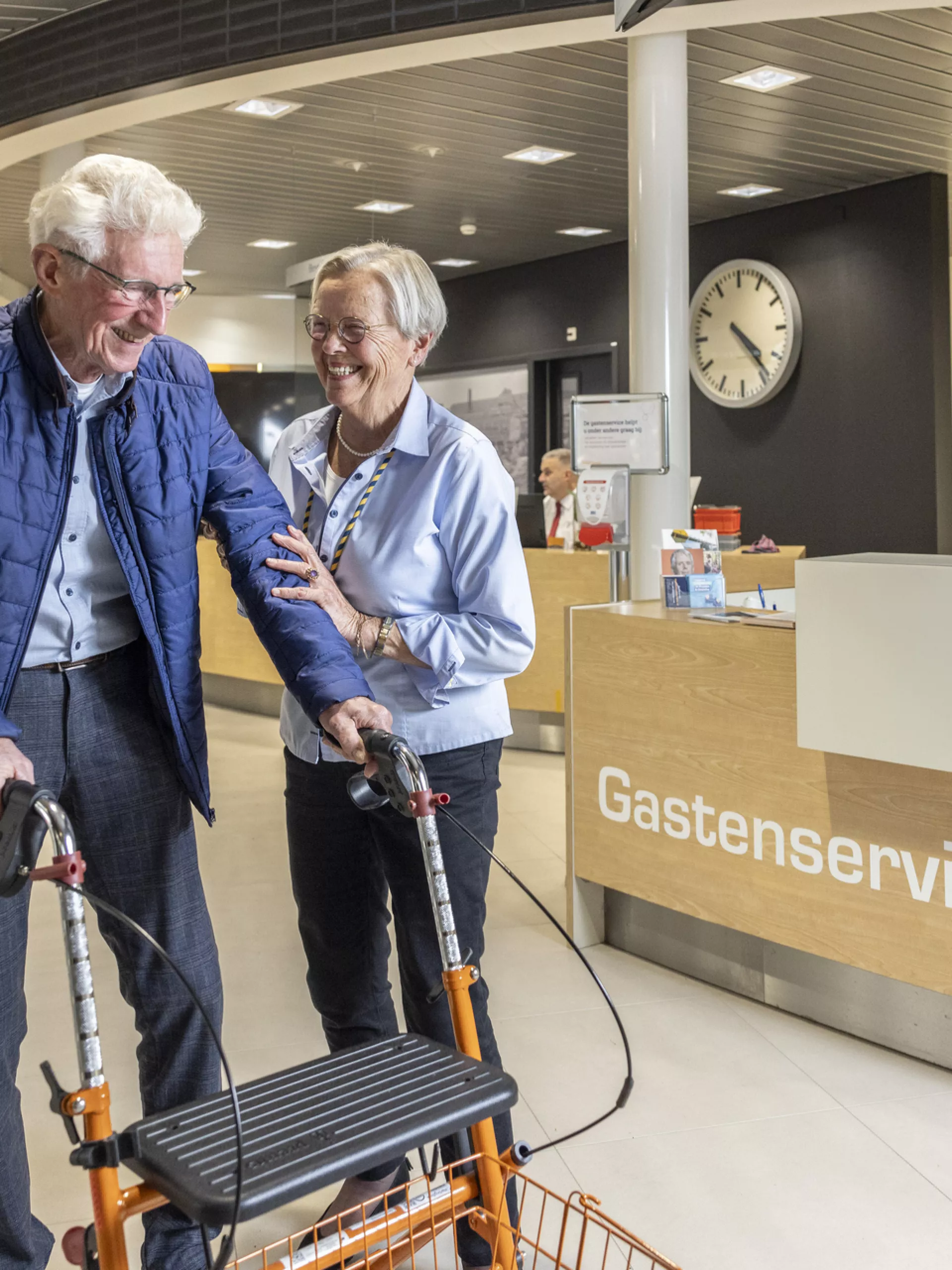 Ouder echtpaar in gesprek bij de gastenservice.