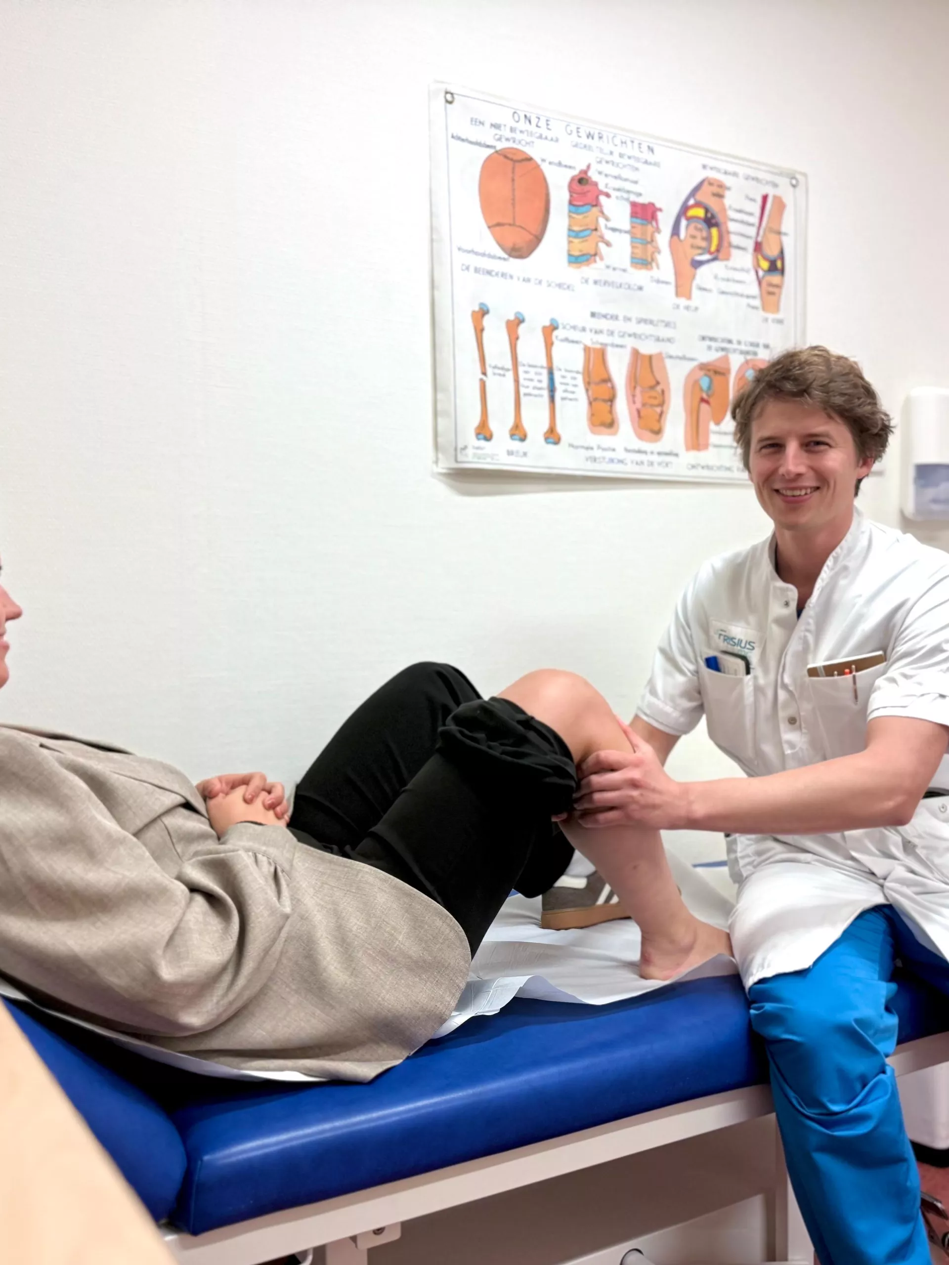 Een arts onderzoekt de knie van een patiënt in een spreekkamer.