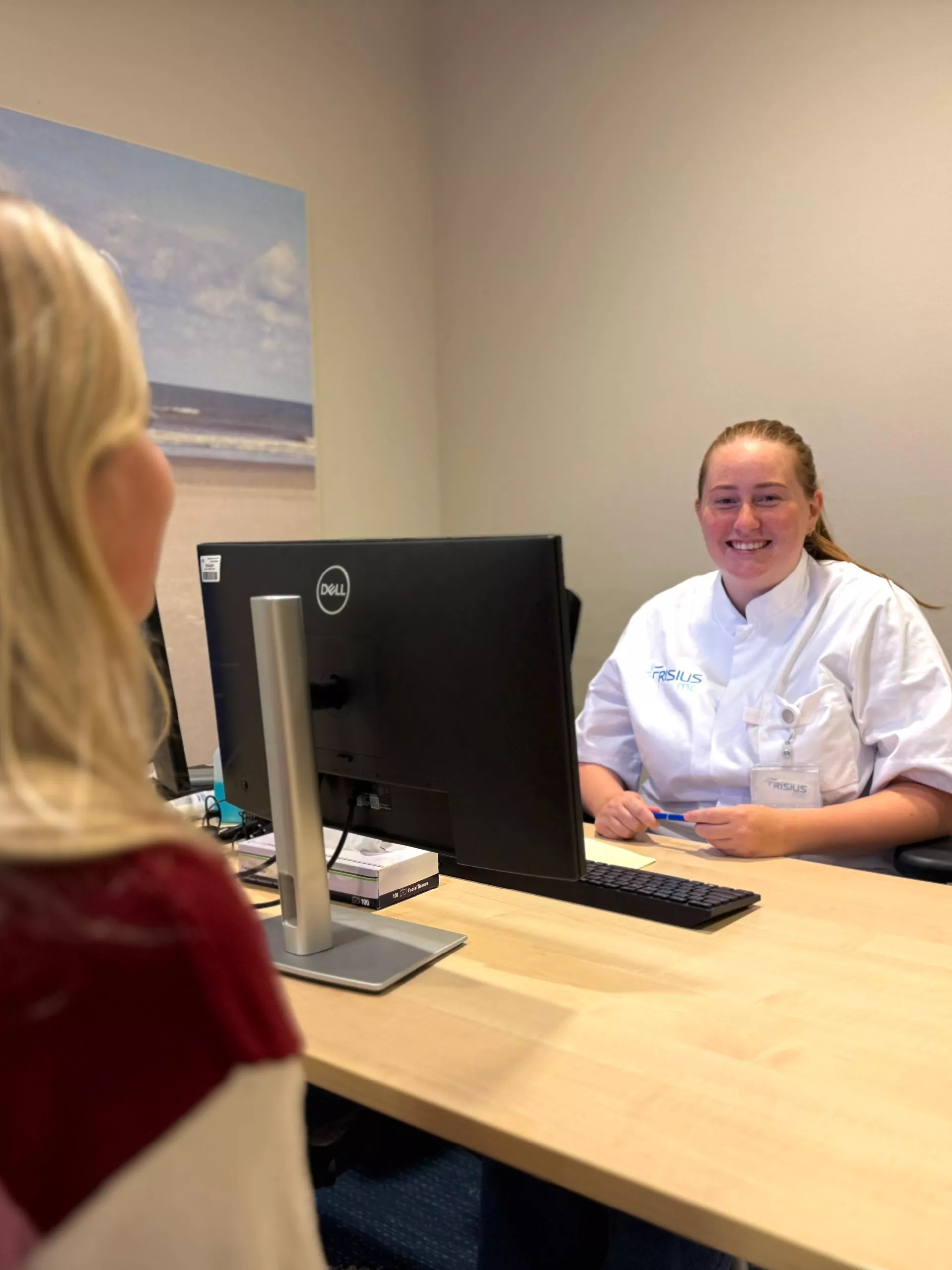 Een vrouw in gesprek met een medisch professional aan een bureau.